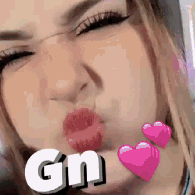 a close up of a woman 's face with hearts around her mouth and the word gn written on it .