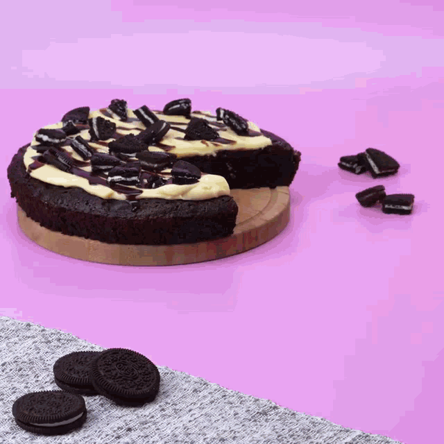 a chocolate cake with oreos on top and a slice taken out of it