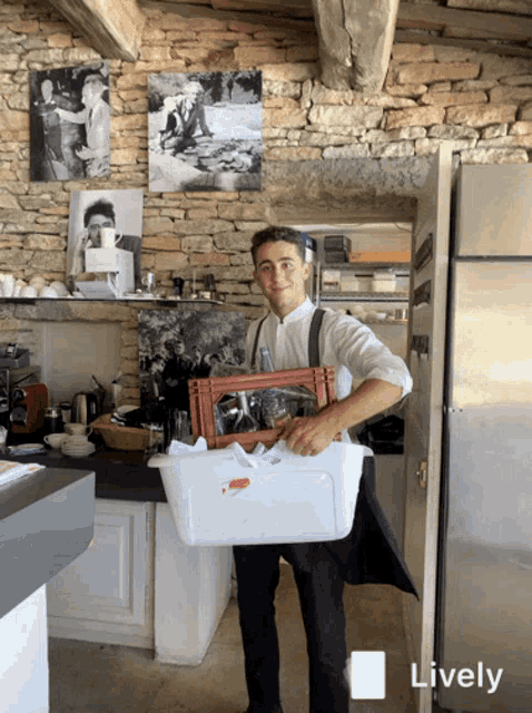 a man carrying a white container and a red crate in a kitchen with a lively icon