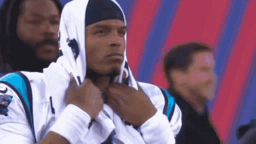 a man wearing a hoodie and a headband is standing in a stadium .