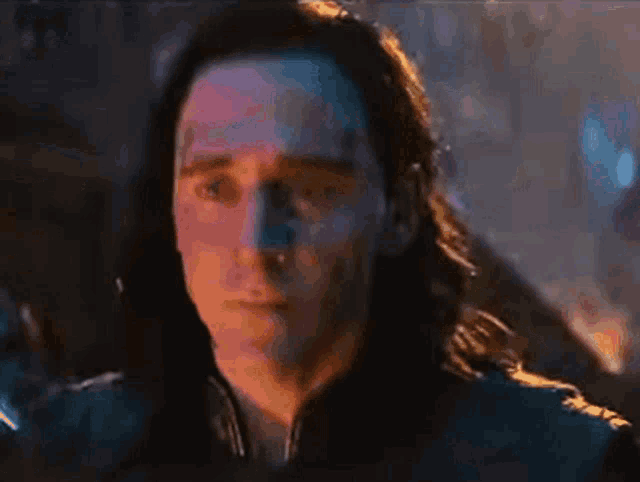 a man with long hair is looking at the camera
