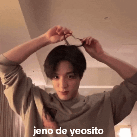 a young man is holding his hair in a ponytail with the words jeno de yeosito above him