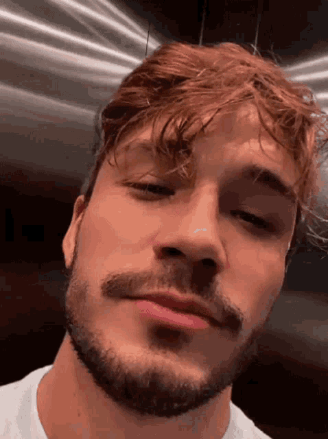 a close up of a man 's face with a beard .