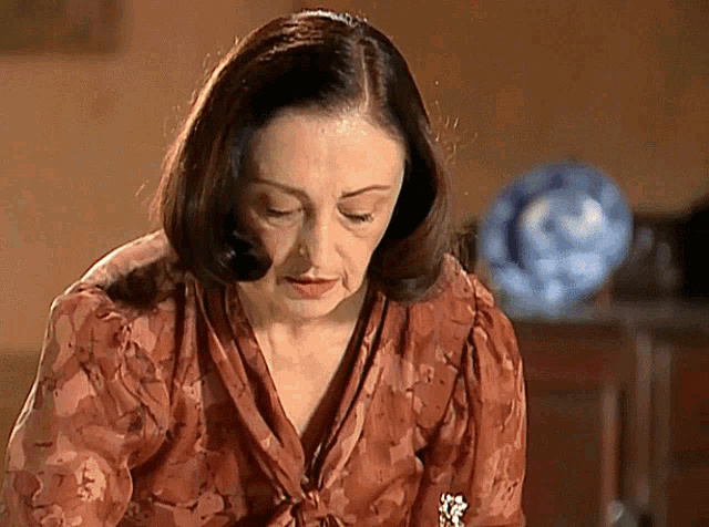 a woman wearing a floral shirt is looking down