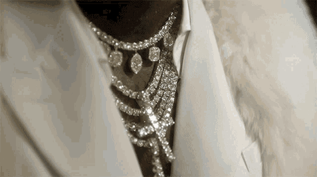 a close up of a person wearing a fur coat and a necklace with diamonds .