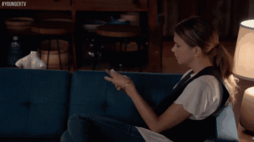 a woman is sitting on a blue couch with the hashtag youngertv visible