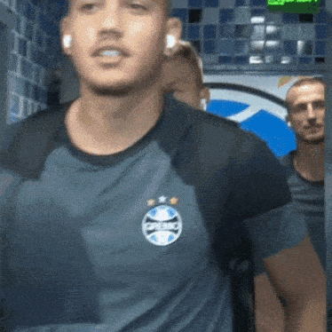 a man wearing ear buds and a shirt that says ' gremio ' on it