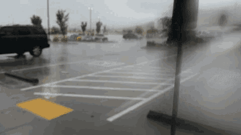 a parking lot in the rain with a handicapped parking spot in the middle