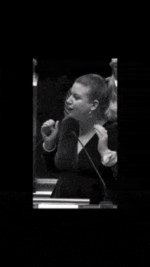 a woman is speaking into a microphone in a black and white photo