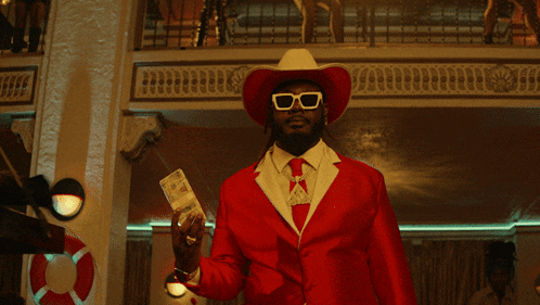 a man in a red suit and cowboy hat is standing next to a woman