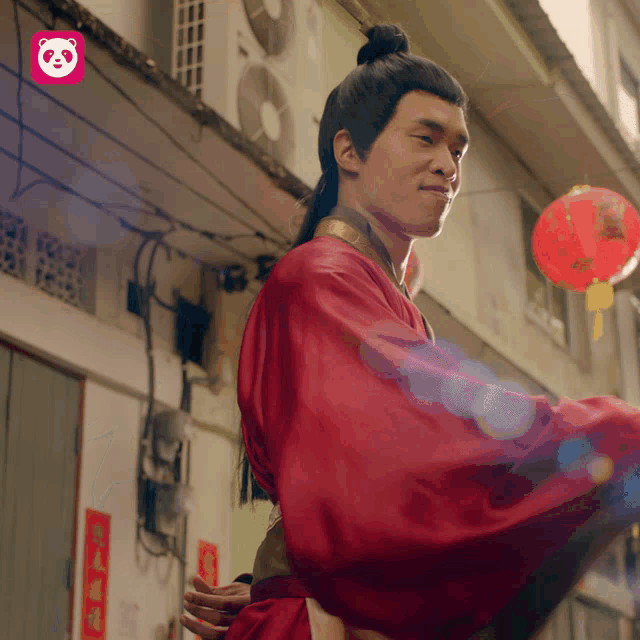 a man in a red robe stands in front of a pink panda bear