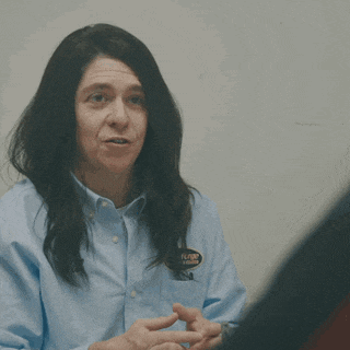 a man with long hair is pointing at something with the words that 's godmode written above him