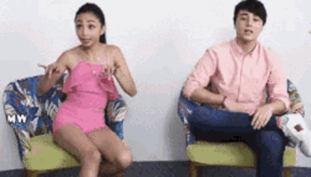 a man and a woman are sitting next to each other in chairs .