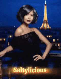a woman in a black dress is standing in front of the eiffel tower with the words saltylicious below her