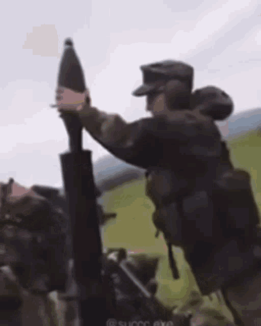 a man in a military uniform is holding a rocket in his hand