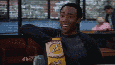 a man is holding a bag of potato chips and smiling