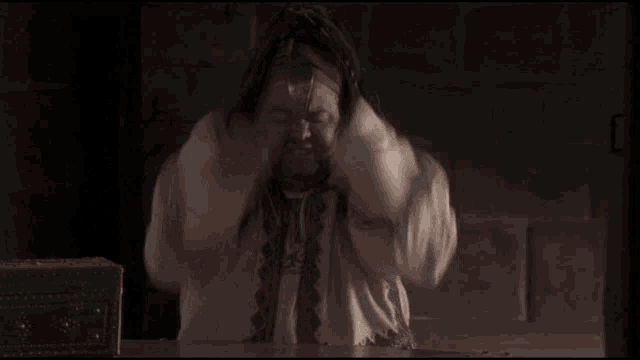 a man with his hands on his head and the word topinambour behind him