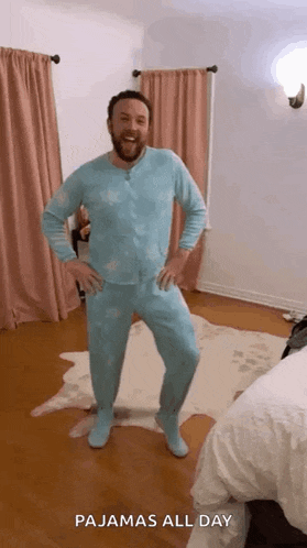a man wearing pajamas is dancing in a bedroom .