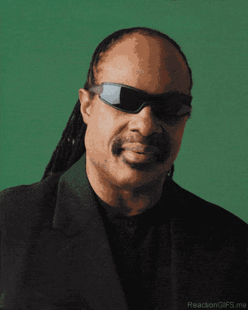 a close up of a man wearing sunglasses and a suit