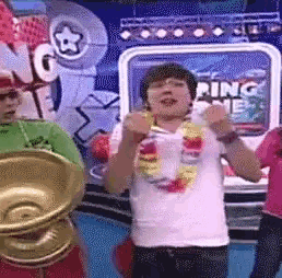 a boy in a white shirt is dancing in front of a sign that says racing