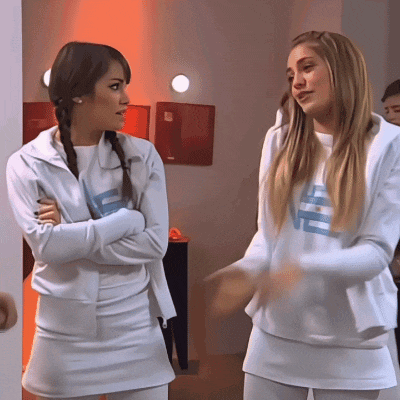 two women wearing white sweatshirts with the letters ve on them are standing next to each other