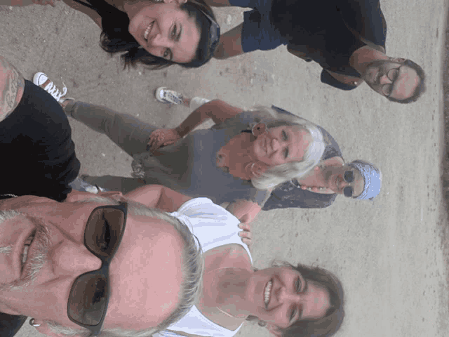 a group of people are posing for a picture and one of them has sunglasses on