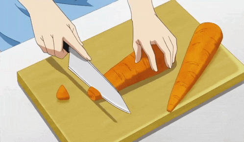 a person is cutting a carrot on a cutting board with a knife