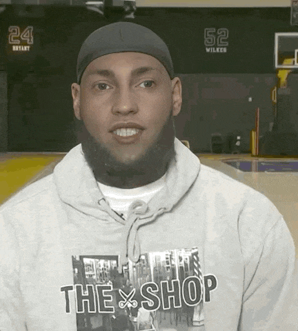 a man wearing a grey hoodie that says the shop on it