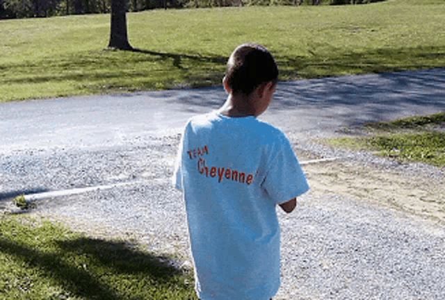 a young boy wearing a white shirt that says team cheyenne