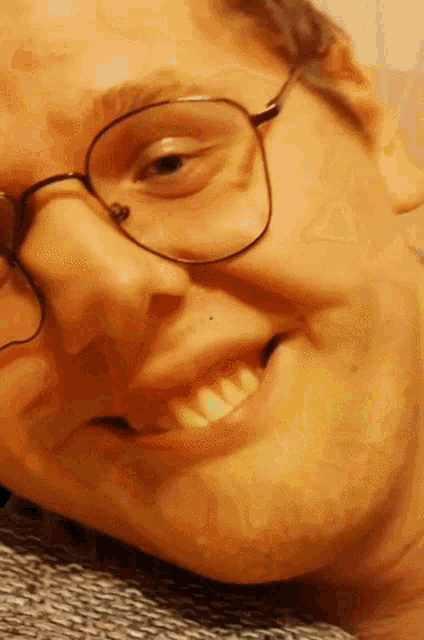 a close up of a man 's face with glasses