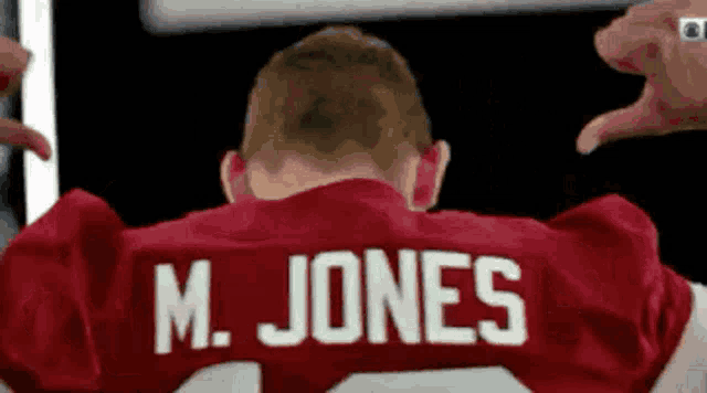 a man wearing a red jersey that says m. jones