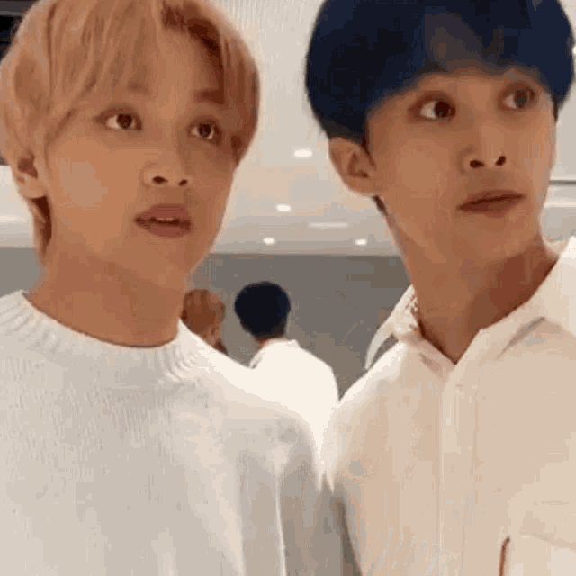 a couple of men are standing next to each other and looking at each other .