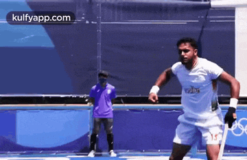 a man in a white shirt is playing soccer on a field .