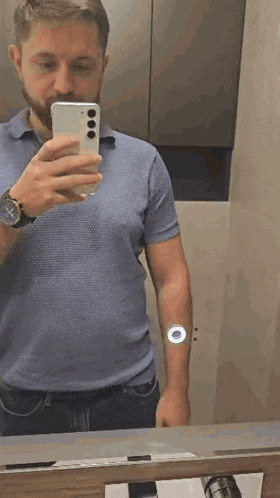 a man is taking a selfie in a bathroom mirror