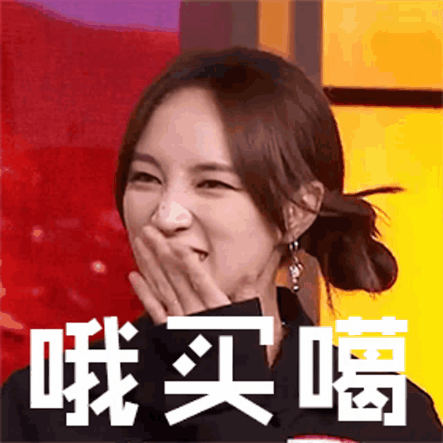a woman is covering her mouth with her hands and laughing .