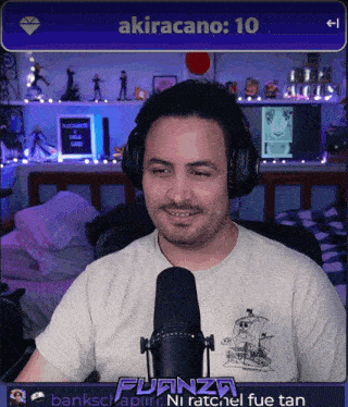 a man wearing headphones is smiling in front of a screen that says akiracano