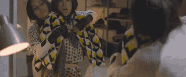 two women are standing in front of a mirror and one is wearing a leopard print jacket