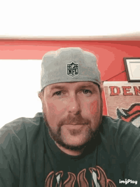 a man wearing a grey nfl hat and a black shirt