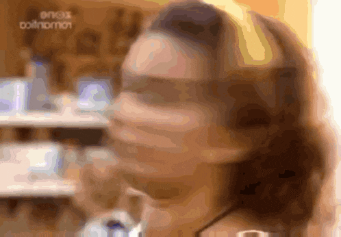 a blurry image of a woman 's face with a sign in the background that says ' oinos '