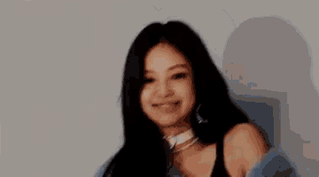 a woman is wearing a blue fur coat and a choker and smiling .