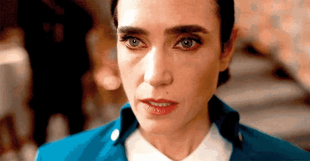 a close up of a woman 's face with a blue jacket .