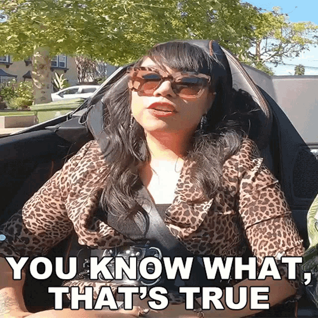 a woman in a leopard print shirt is sitting in a car and says you know what that 's true