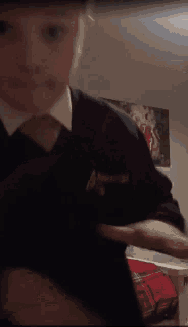 a boy wearing a black sweater and tie has a badge on his chest that says ' abercrombie & fitch '