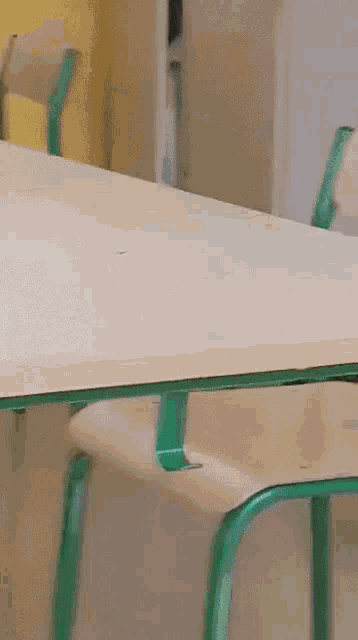a person 's arm is sticking out of a cabinet behind a table