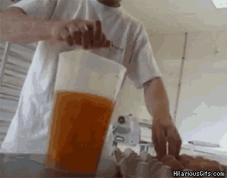 a man in a white shirt is pouring orange juice into a plastic pitcher .