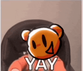 a person is holding a teddy bear with a smiley face and the words yay on it .