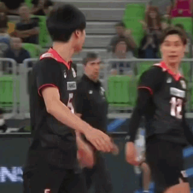 two basketball players are standing next to each other on the court .