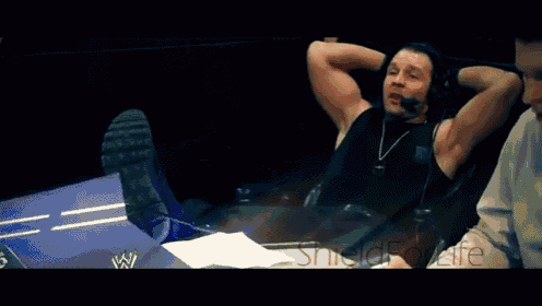 a wrestler is making a funny face while wearing a sleeveless shirt with the letter w on it
