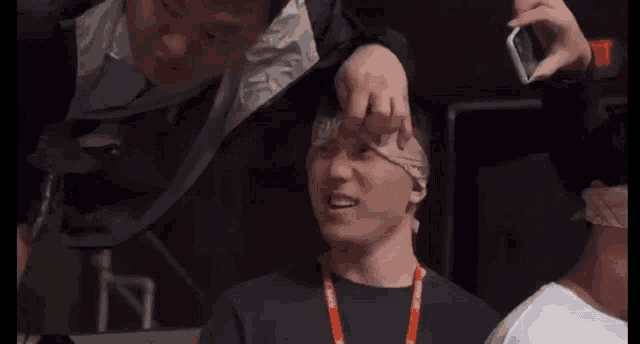 a person is covering their eyes with their hands while sitting in a stadium .
