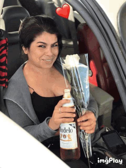 a woman in a car holding a bottle of modelo beer and a rose